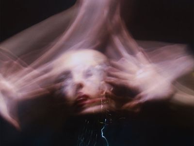 Blurred motion of a person performing a dynamic stretch.