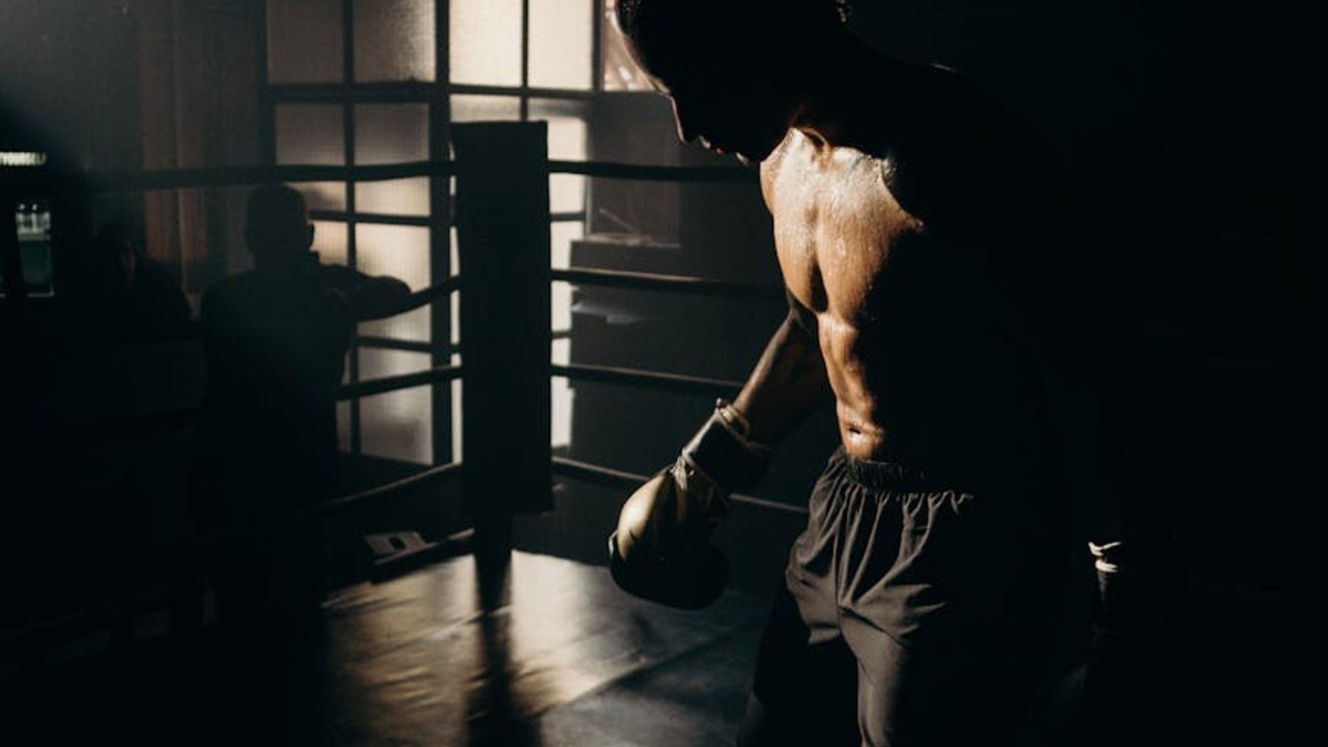 Silhouette of a man in a power stance against a dark background.